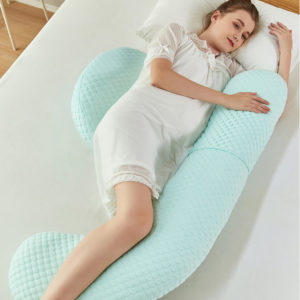 Oreiller de grossesse molletonné et tout doux vert. Femme enceinte allongé dedans une main en l'air sur l'oreiller, l'autre sur le coussin.