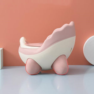 Pot ergonomique bébé en forme de coquillage rose et blanc. Mur fond orangé.