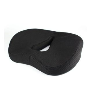 Coussin ergonomique noir avec un trou au milieu en forme de goutte.