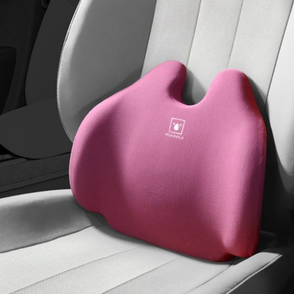 Coussin ergonomique rose avec un logo blanc au milieu. Le coussin est posé sur un siège de voiture gris clair.