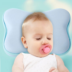 Oreiller dodo ergonomique pour bébé bleu en forme de nuage. Bébé avec tétine rose appuie sa tête.