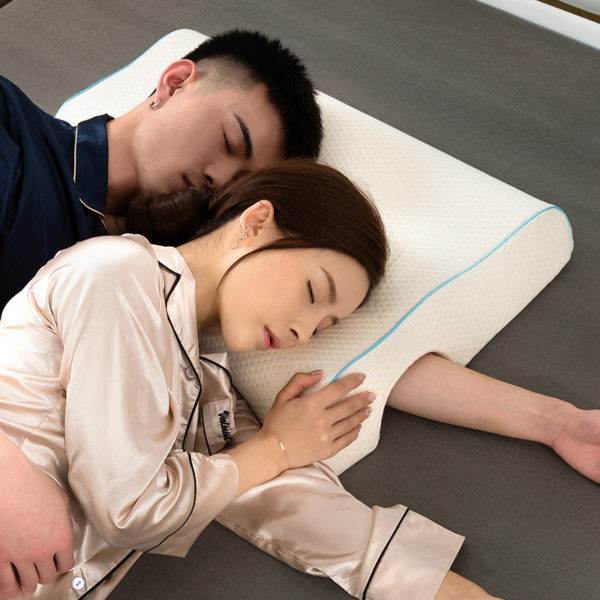 Deux personnes qui dorment sur un oreiller blanc. Le couple est allongé sur un lit marron.
