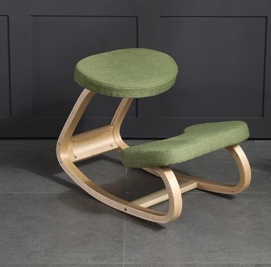 Siège ergonomique avec assise à genoux. Cadre en bois de bouleau clair et coussins verts. Placé au centre d'un fond gris.