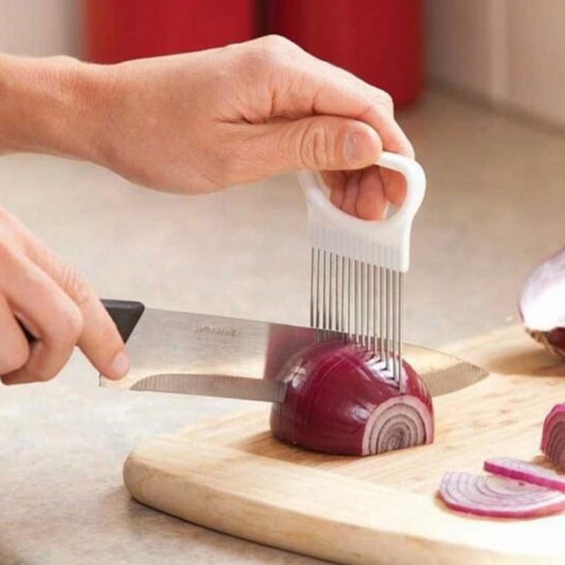 Fourchette à Légumes Ergonomique en Acier Inoxydable et Plastique dans les mains d'une personne en train de couper un oignon