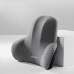 Coussin Ergonomique Dos pour Siège de Voiture à Mémoire de Forme posé contre un cube blanc sur fond gris