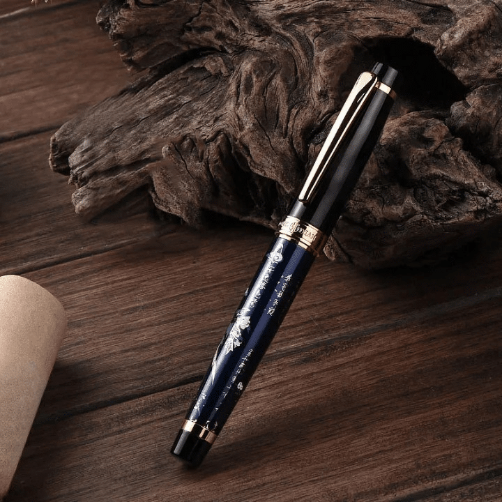 Stylo Ergonomique à Plume avec Convertisseur et Motif Floral posé contre un morceau de bois avec un bouchon en liège à gauche