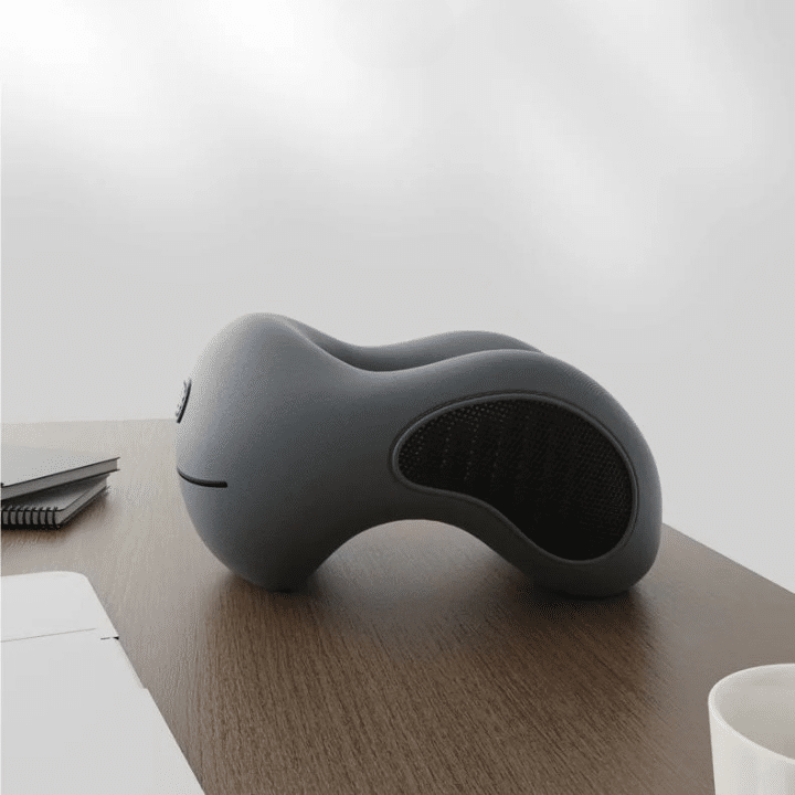 Oreiller Anti Ronflement Gris et Ergonomique pour Bureau sur une table sur fond gris