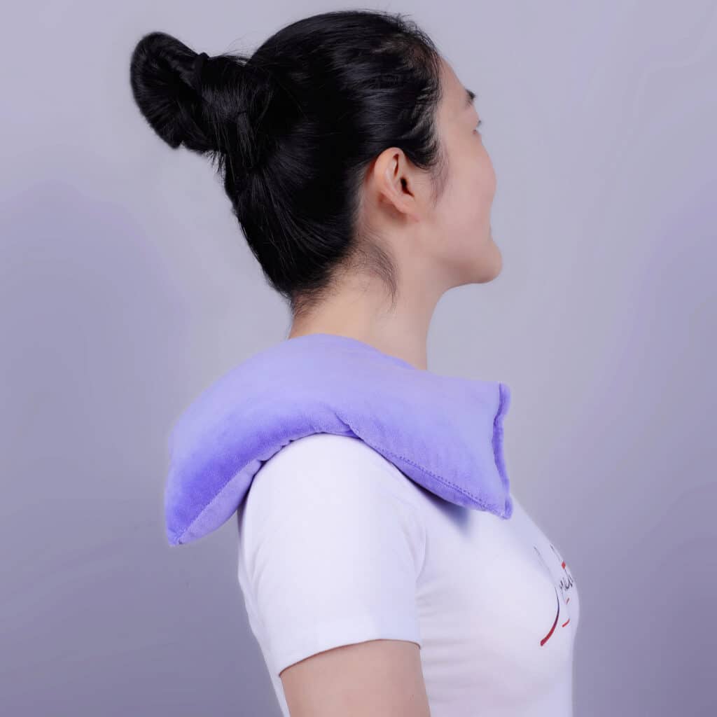 Coussin Ergonomique Cervicales Chauffant et Relaxant posé sur l'épaule d'une femme