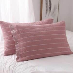 Lot de Deux Housses de Coussin Ergonomique Modernes et Élégantes sur des coussins sur un lit