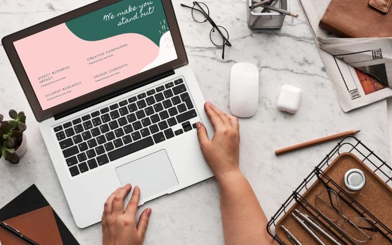 Bureau vu d'e haut avec un ordinateur portable, des lunettes de vu, un souris et des accessoires de télétravail.