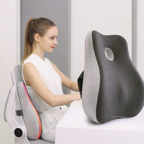Coussin lombaire dos : guide pour soulager vos douleurs Coussin lombaire dos en forme ergonomique, placé sur une chaise avec une personne utilisant l’appui pour améliorer la posture.