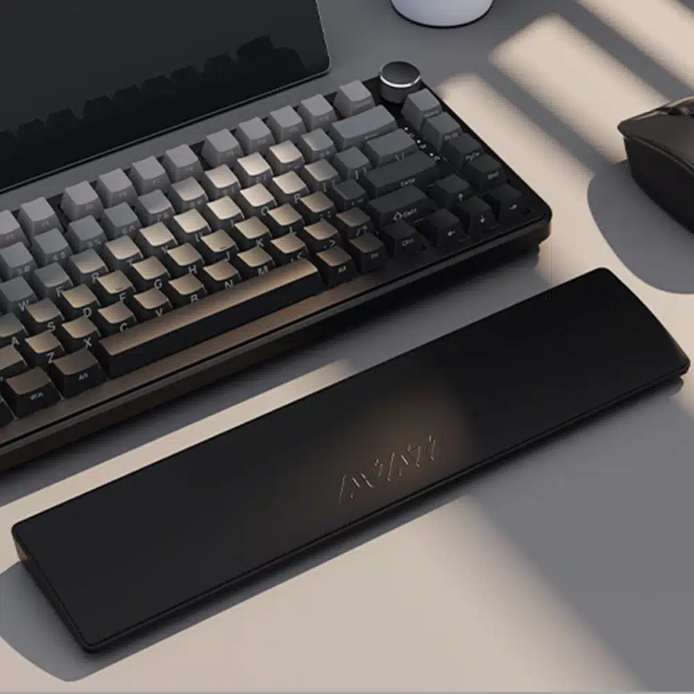 Repose-poignet ergonomique pour clavier : comment choisir Repose-poignet posé devant un clavier sur un bureau, avec un tapis ou repose-poignet noir et une souris partiellement